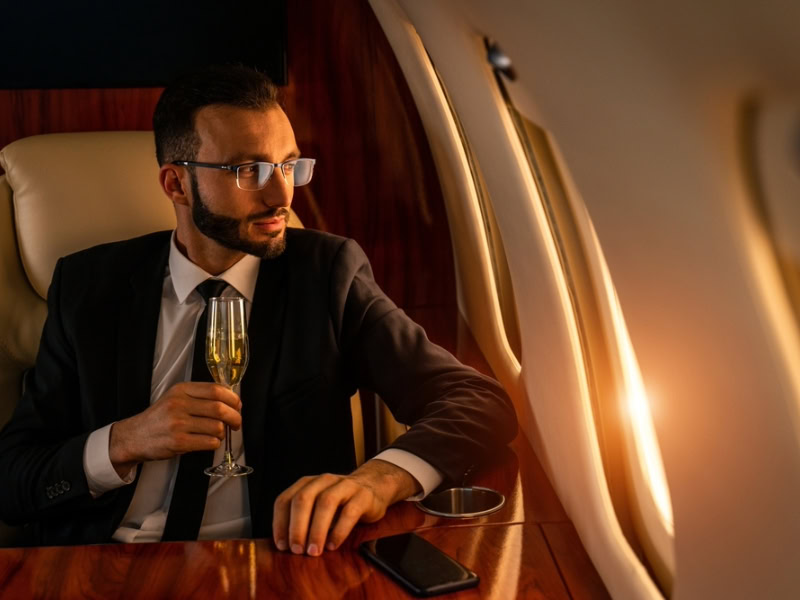 a business man sitting in private jet looking at window