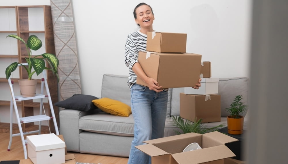 elated woman moving boxes